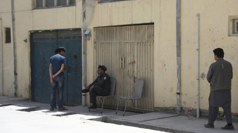 A policeman center, sits near the gate of a foreign guesthouse in Kabul, Afghanistan. (Photo: AP)