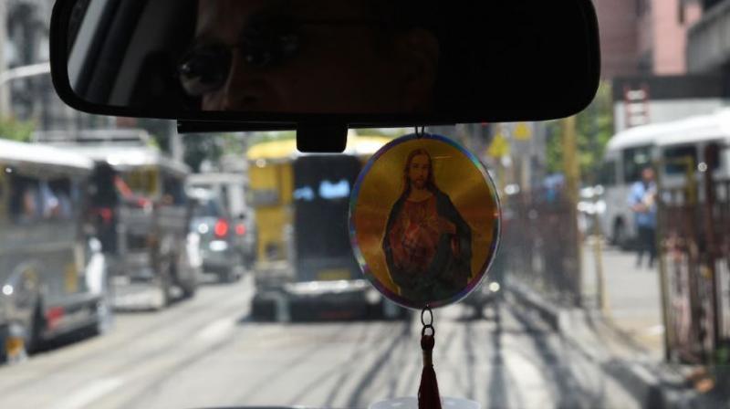 A Filipino taxi driver displays a religious icon inside his vehicle in Manila. (Photo: AFP)