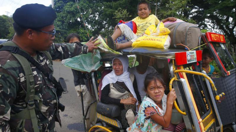 Residents fleeing the besieged city of Marawi are questioned at a checkpoint by government soldiers, in Bal-oi township, southern Philippines. (Photo: AP)