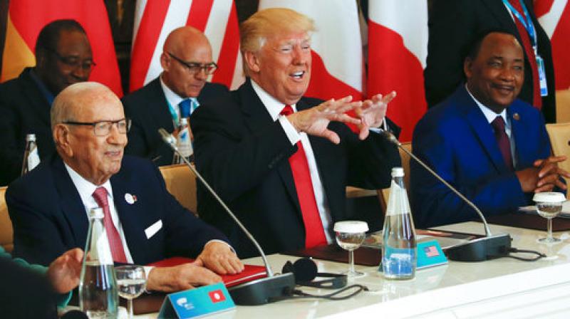US President Donald Trump gestures while being flanked by Tunisias President Beji Caid Essebsi, left, and Nigers President Mahamadou Issoufou, right, at a G7 Summit expanded session in Taormina, Italy. (Photo: AP)
