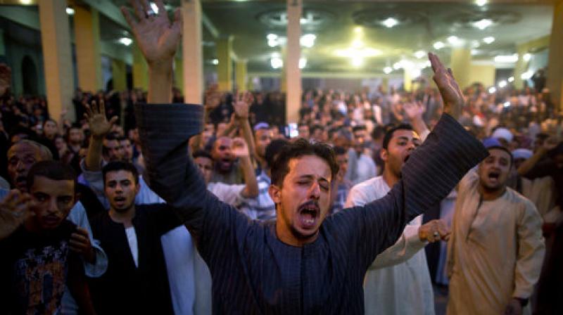 Coptic Christians shout slogans during a funeral service for victims of a bus attack, at Abu Garnous Cathedral in Minya, Egypt. (Photo: AP)