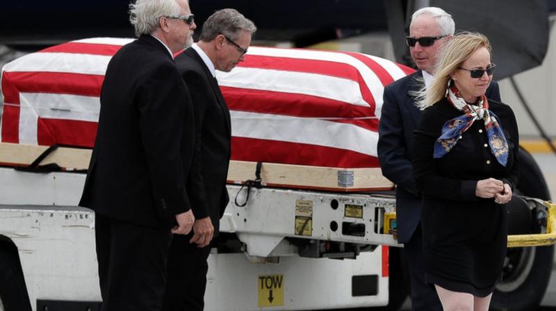 Deborah Crosby, right, walks away from her fathers casket after its arrival to the airport Friday in San Diego. (Photo: AP)