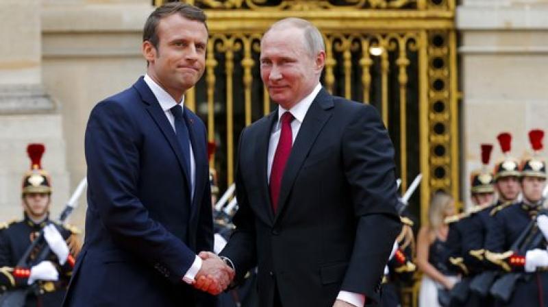 Russian President Vladimir Putin, right, is welcomed by French President Emmanuel Macron at the Palace of Versailles, near Paris, France. (Photo: AP)