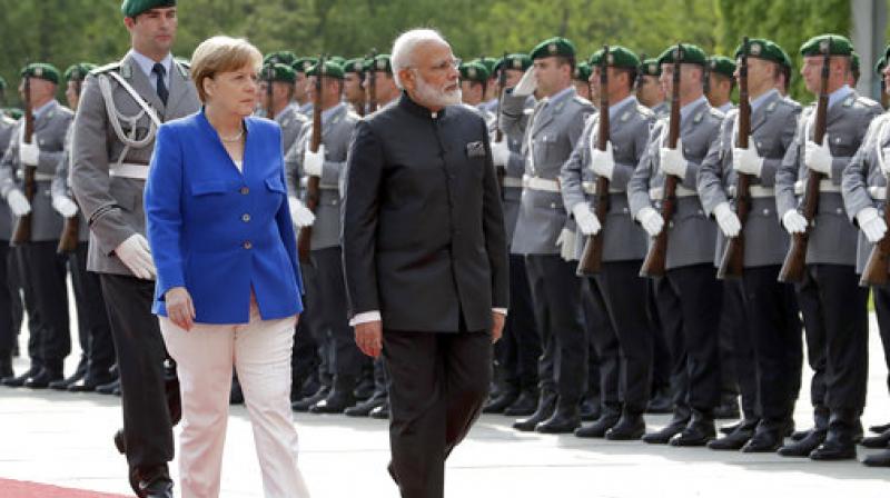 German Chancellor Angela Merkel, left, welcomes the Prime Minister of India, Narendra Modi, right, with military honors for a meeting at the chancellery in Berlin, Germany. (Photo: AP)