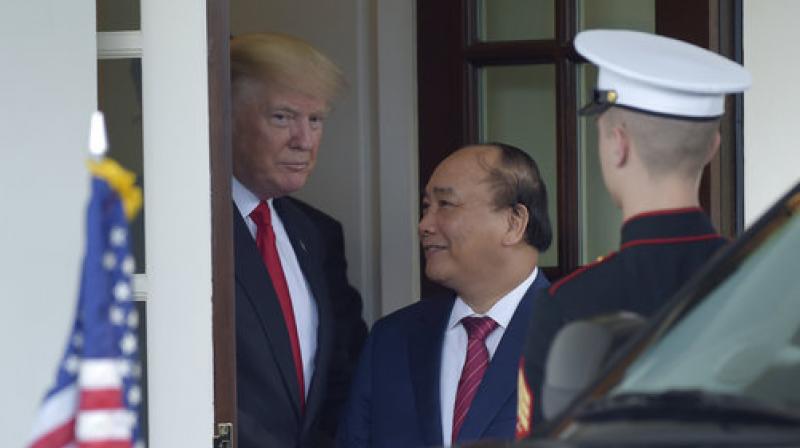 President Donald Trump walks Vietnamese Prime Minister Nguyen Xuan Phuc to his car following their meeting at the White House in Washington. (Photo: AP)