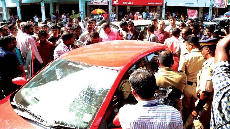 A large crowd gathered near the Jawaharlal Nehru Stadium on Thursday as intelligence officials from the IT department intercepted a car used by four-member gang suspected to be involved in currency exchange. 	(Photo: DC)