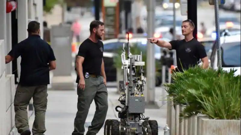 Bomb squad police prepare a robot to enter a parking garage a block away from the scene of a multiple shooting at the Jacksonville Landing on Sunday. (Photo: AP)