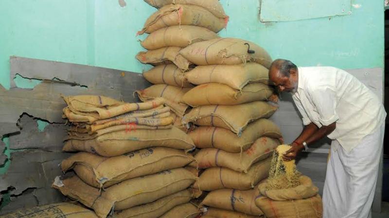 A ration shop owner in Thiruvananthapuram checking the quality of rice.  (Photo: DC)