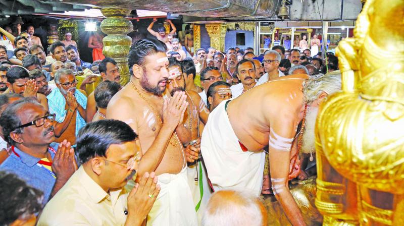 Sabarimala melsanthi Unnikrishnan Nampoothiri opens the sanctum sanctorum of the temple for the monthly pooja at Sannidhanam on Wednesday. Thantri Kandararu Rajeevaru is also seen.