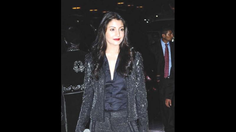 Anushka Sharma balances out her sequin pant suit with a plain black silk blouse and heels, a perfect New Years Eve look.