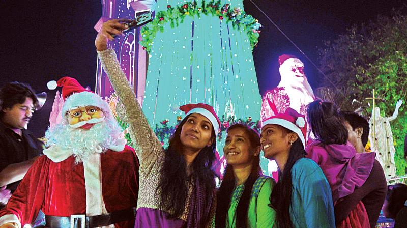 Girls take a selfie at St. Marys Basilica at Shivajainagar on the eve of Christmas celebration in Bengaluru on Saturday. (Photo:Satish B)