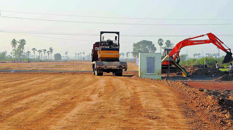 Workers and machines busy in road-laying work for the Amaravati Seed Access Road in the pooled farmlands of Venkatapalem village of Amaravati Capital Region on the banks of Krishna river. (Photo: Tejo Roy Eleti)
