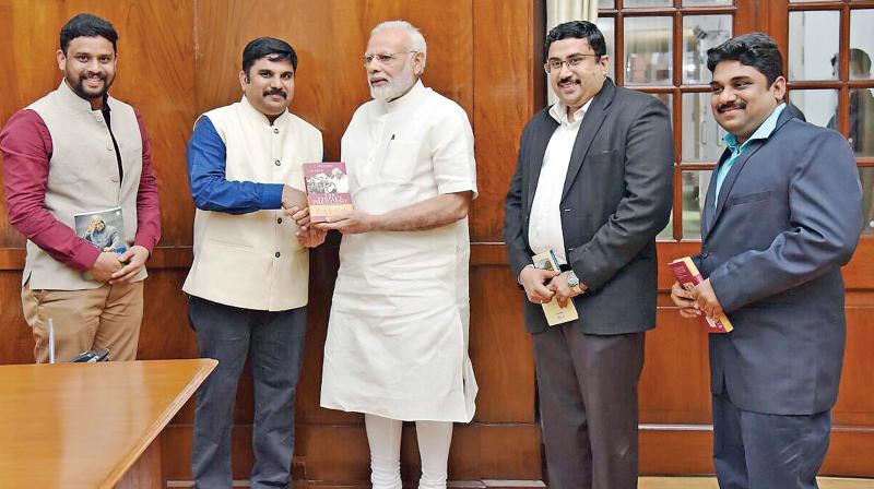 A.P.J. Sheik Saleem presents Kalams book Pathway of Greatness to PM Modi. His brothers Sheik Dawood and G.K. Moideen are at the extreme right while Green Man of India Abdul Ghani is on his right. (Photo: DC)