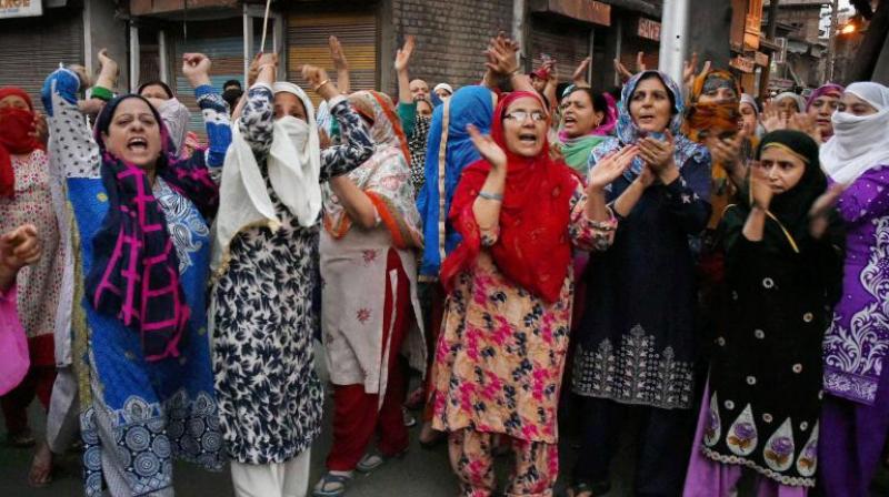 Women shout slogans and block a road during a protest against braid choping incidents in the Valley, at Habakadal in Srinagar. (Photo: PTI)