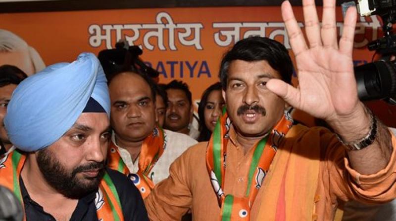 Delhi BJP President Manoj Tiwari with newly joined party member Arvinder Singh Lovely (left) at a press conference in New Delhi on Tuesday. (Photo: PTI)