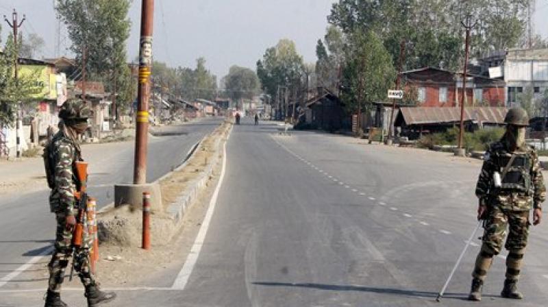 Security Personnel stand guard on a deserted street in Srinagar. (Photo: PTI)