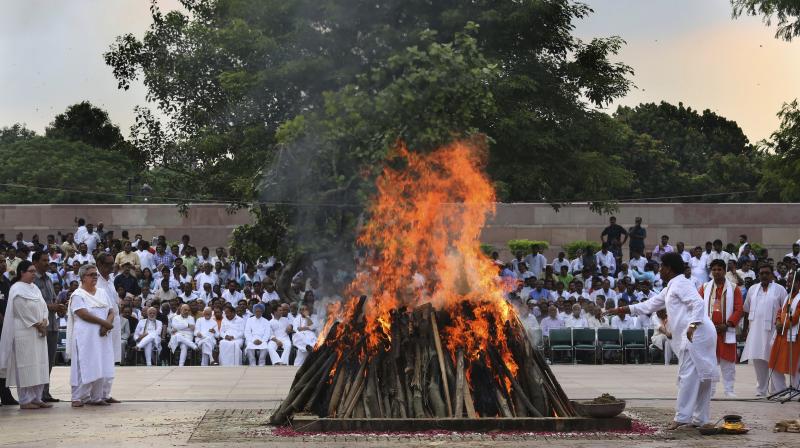Flames rise from the funeral pyre of former Indian Prime Minister Atal Bihari Vajpayee, watched by his foster daughter Namita Bhattacharya on the banks of the River Yamuna in New Delhi on Friday. (Photo: AP)