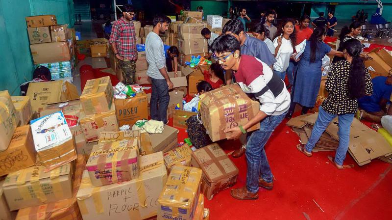 Anbodu Kochi volunteers and District Civil officers organise relief material to be sent to flood affected areas in Kochi. (Photo: PTI)