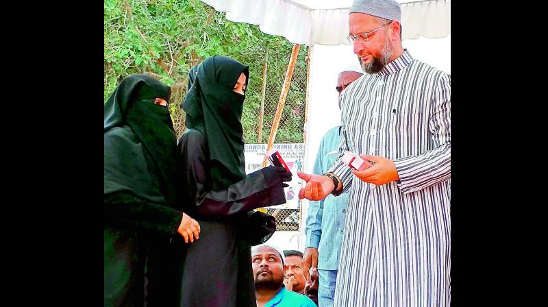 Hyderabad MP and AIMIM president Asaduddin Owaisi distributes pepper spray to female students for their safety during the launch of the Women & Child Safety Awareness Campaign on Tuesday. (Photo: Gandhi)