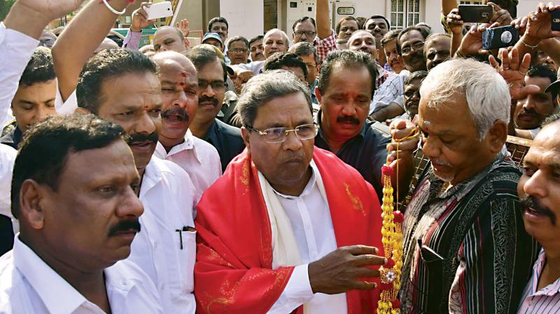 Chief Minister Siddaramaiah being welcomed by their respective supporters in Mysuru on Monday. (Photo: KPN)