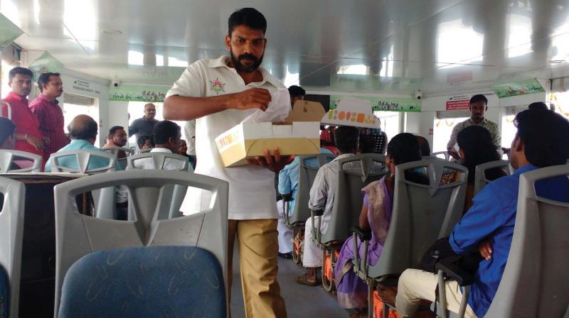 The staff of Aditya distribute sweets to passengers in connection with second anniversary of inception of the boat.