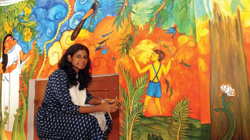 Lekha beside the mural of poem Mambazham.