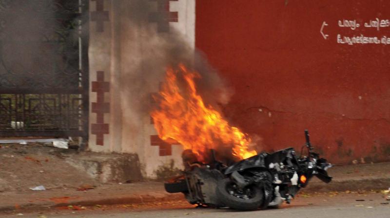 A bike burnt by the miscreants in front of the University College in the backdrop of hartal called by BJP on Sunday. (Photo: Peethambaran Payyeri)
