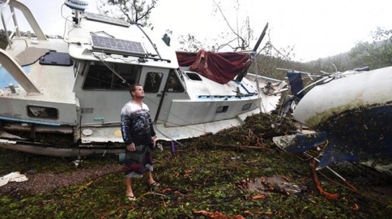Bradley Mitchell inspects the damage to his uncles boat after it smashed against the bank at Shute Harbour, Airlie Beach, Australia (Photo: AP)
