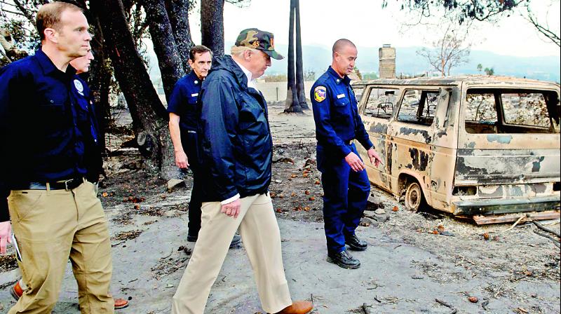 US President Donald Trump walks through the burned areas from the wildfires in Malibu, California, on Saturday.(Photo:  AFP)