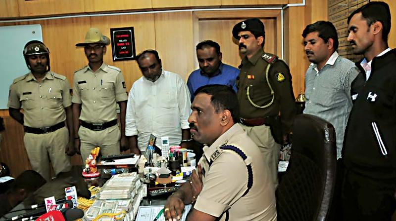 Bengaluru city police with the sandalwood racket accused Syed Riyaz  and his son, Sher Ali during a press conference at DCPs office in Cubbon Park in Bengaluru on Saturday  (Image DC)