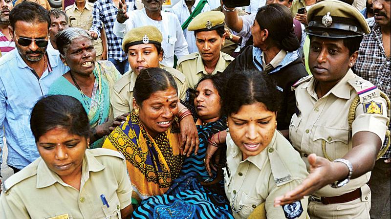 A woman protester who collapsed is carried away by cops.