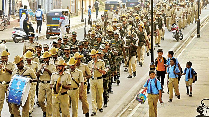 Policemen carry out a flag march in Mysuru on Tuesday ahead of Tipu Jayanti celebrations on Thursday