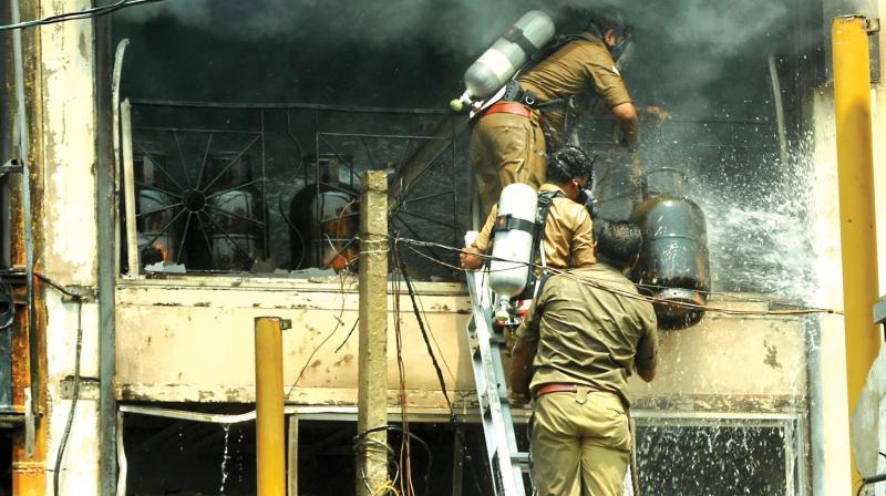Firemen remove gas cylinders from a gutted textiles shop on SM Street in Kozhikode on Wednesday. A major tragedy was averted due to this as fire at the three-storeyed textile shop blazed for nearly five hours. (Photo: Venugopal)