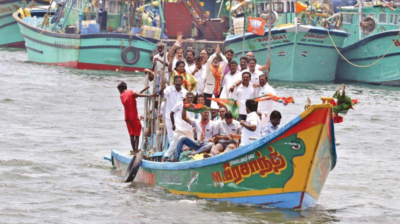 BJP candidate for RK Nagar Gangai Amaran and party state president Dr Tamilisai Soundararajan take to the water in Kasimedu fishing harbour on Monday for poll canvassing. (Photo: DC)