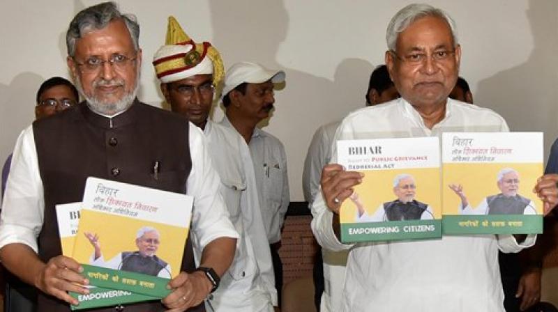 Bihar Chief Minister Nitish Kumar with Deputy CM Sushil Kumar Modi release a book on completion of two years since the implementation of Bihar Public Grievance Redressal Rule Act, in Patna on Tuesday. (Photo: PTI)