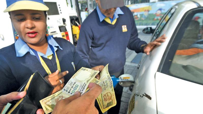 A customer pays for fuel with old 500 rupee notes at a petrol station in New Delhi on Friday, the last day on which the old currency can be used to  purchase fuel. (Photo: AP)