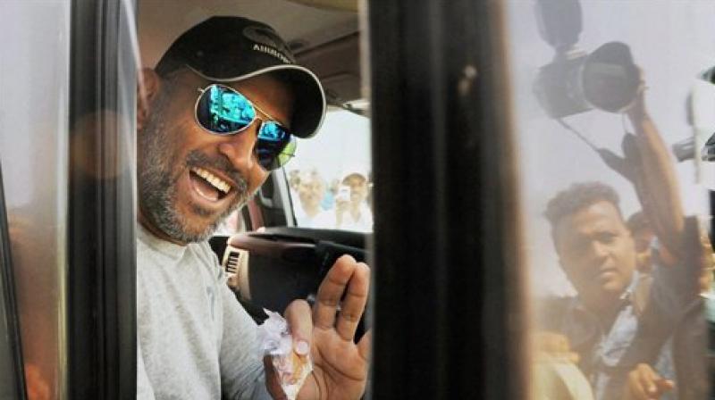 MS Dhoni waves at fans from his SUV after being spotted outside Ranchis Birsa Munda airport. (Photo: PTI)