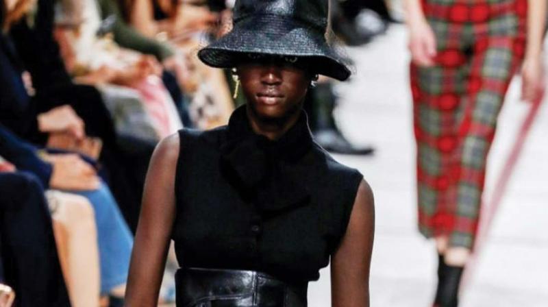 A model wearing a bucket hat and leather cumberband at the Diors tartan-heavy Paris autumn winter show.