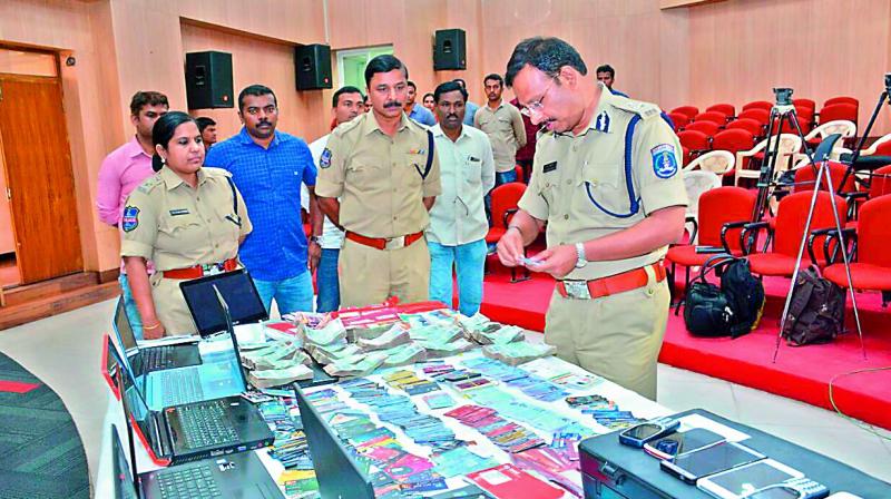 Cybercrime cops with the seized identity cards. ( Image: DC)