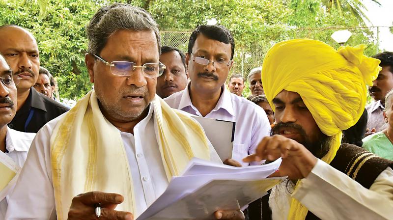 CM Siddaramaiah receives a petition from a man at his residence in Bengaluru on Tuesday (Phot: DC)