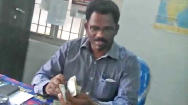 A video grab shows government staff purportedly taking bribe from an aspiring entrepreneur. (Photo: DC)