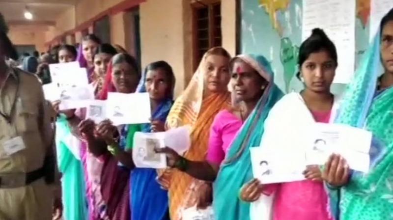 Women queue up outside booth no.50 in Hirepadasalgi village of Jamkhandi to cast their votes. (Photo: ANI/Twitter)