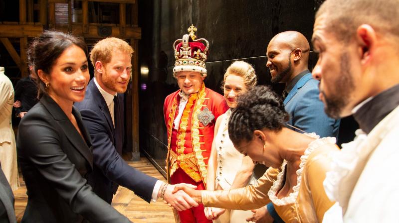 Britains Prince Harry, Duke of Sussex, (2L) and Britains Meghan, Duchess of Sussex (L) meet members of the cast and crew backstage after a gala performance of the musical Hamilton in support of the charity Sentebale at the Victoria Palace Theatre in London on August 29, 2018. (Photo: AFP)