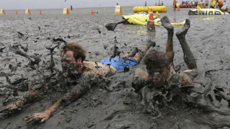 Men slide in the mud during the Boryeong Mud Festival at Daecheon Beach in Boryeong, South Korea, Saturday, July 22, 2017.(Photo: AP)