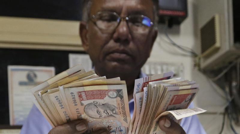 A man counts Rs 1000 currency notes at a fuel pump in Ahmadabad. (Photo: AP)