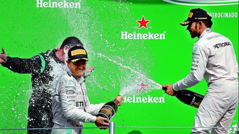Mercedes Lewis Hamilton (right) celebrates with team mate Nico Rosberg after winning the Mexico GP at the Hermanos Rodriguez racetrack on Sunday. Hamilton finished ahead of Rosberg and Ferraris Sebastian Vettel. (Photo: AP)