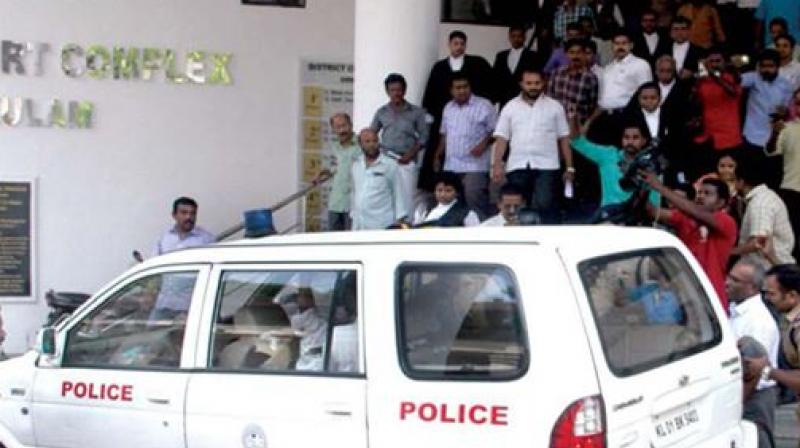 Lawyers, media persons and other onlookers gather at the court premises as the police team brings Pulsar Suni and Vijeesh to a police vehicle. (Photo: DC)