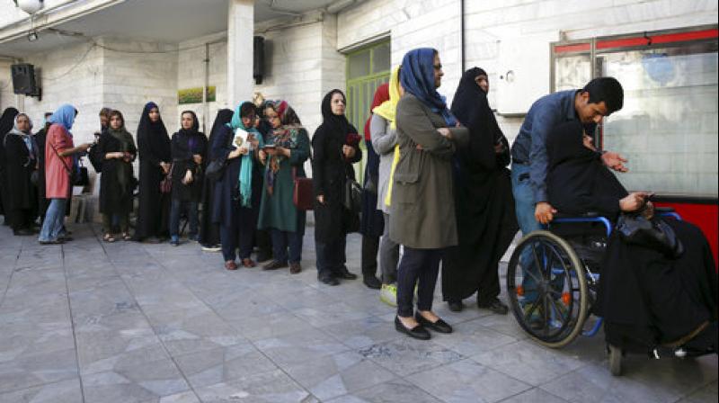 Iranian voters queue at a polling station for the presidential and municipal council election in Tehran (Photo: AP)