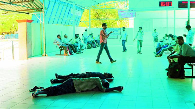 Railway commuters are forced to rest on the floor due to shortage of chairs and benches in the waiting hall at Guntur railway station. (Photo: DC)