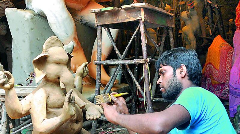 An artist prepares the idols of Ganesha at a makeshift workshop near Convent Junction in Visakhapatnam on Monday. (Photo: DC)